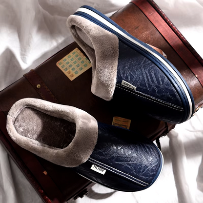 Pair of blue and gray slippers on a suitcase with a white background