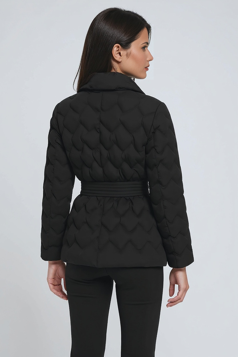 Woman wearing a black quilted jacket on a white background