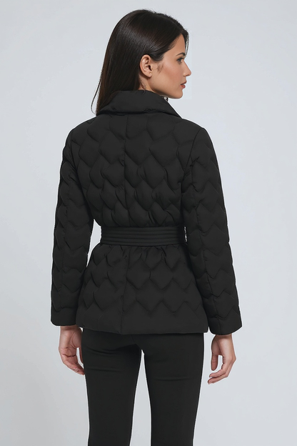 Woman wearing a black quilted jacket on a white background