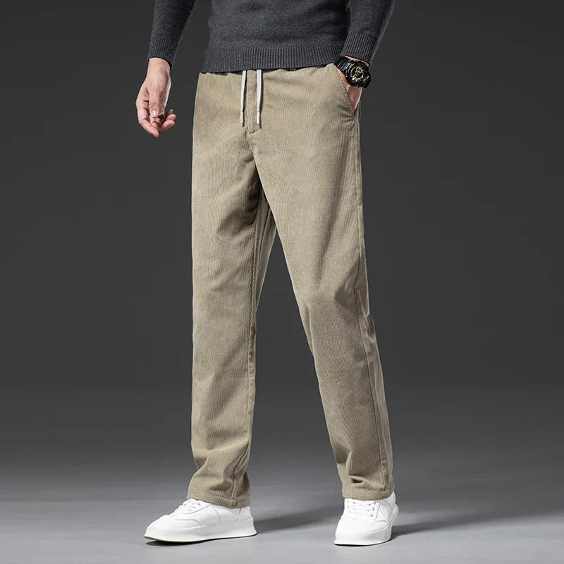 Beige corduroy pants worn by a person on a gray background