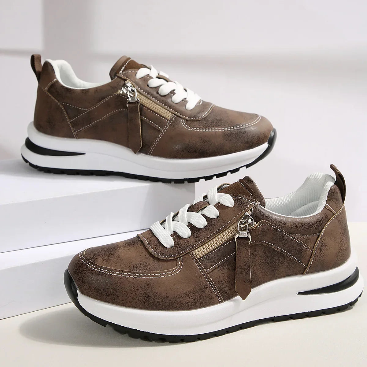 Brown sneakers with white laces and soles on a light background