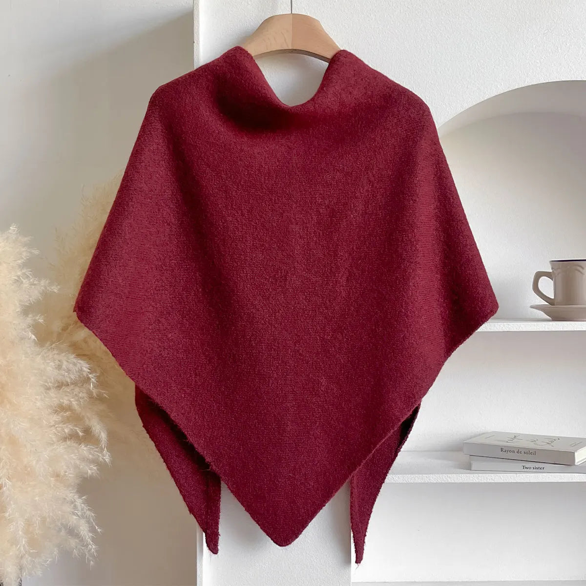 Red poncho on a wooden hanger against a white background