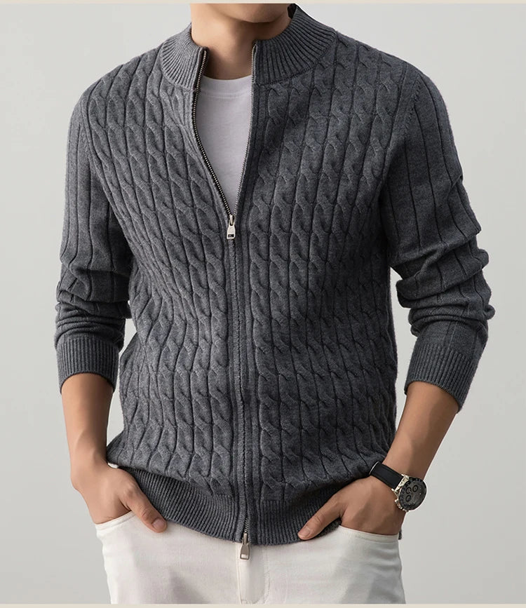 Person wearing a gray cable knit sweater with a zipper on a light gray background