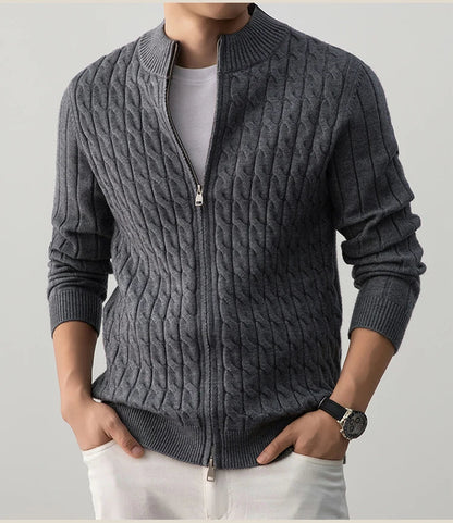 Person wearing a gray cable knit sweater with a zipper on a light gray background