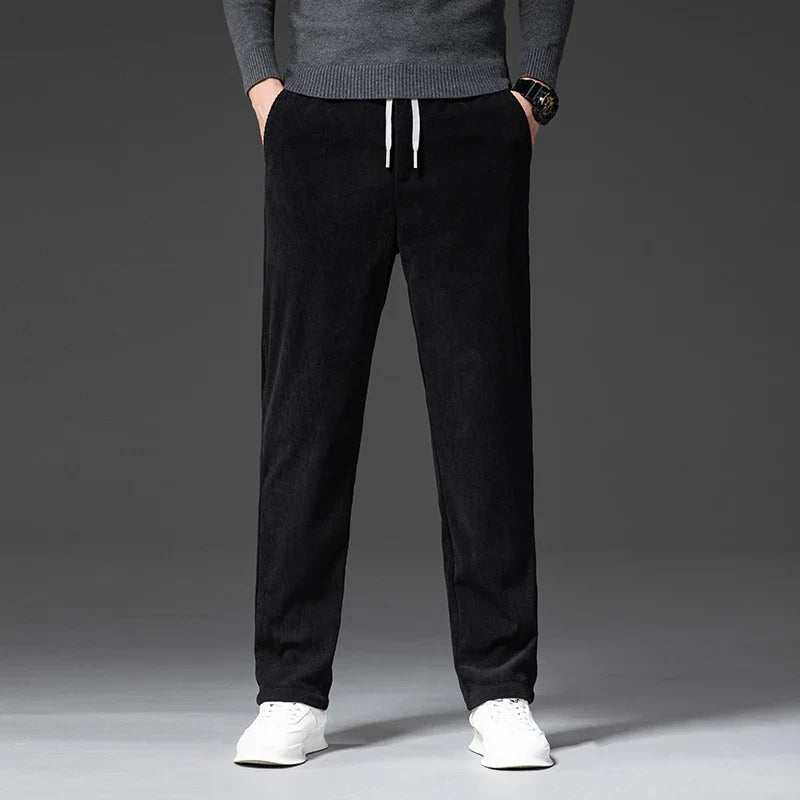 Person wearing black pants and a gray sweater on a gray background