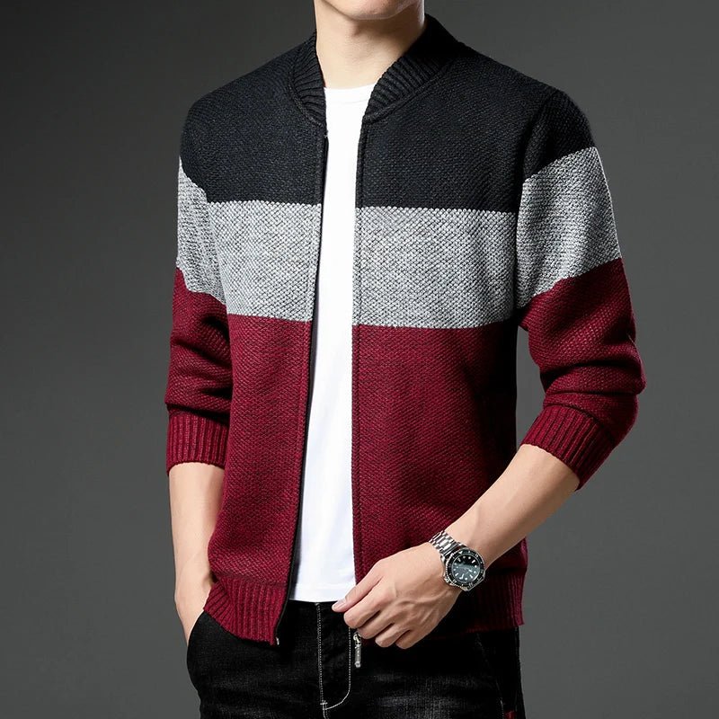 Person wearing a black, gray, and red striped sweater on a gray background