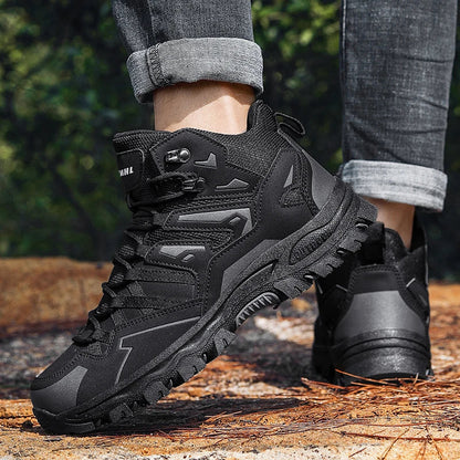 Black tactical boots on a person standing on a wooden surface with a blurred natural background