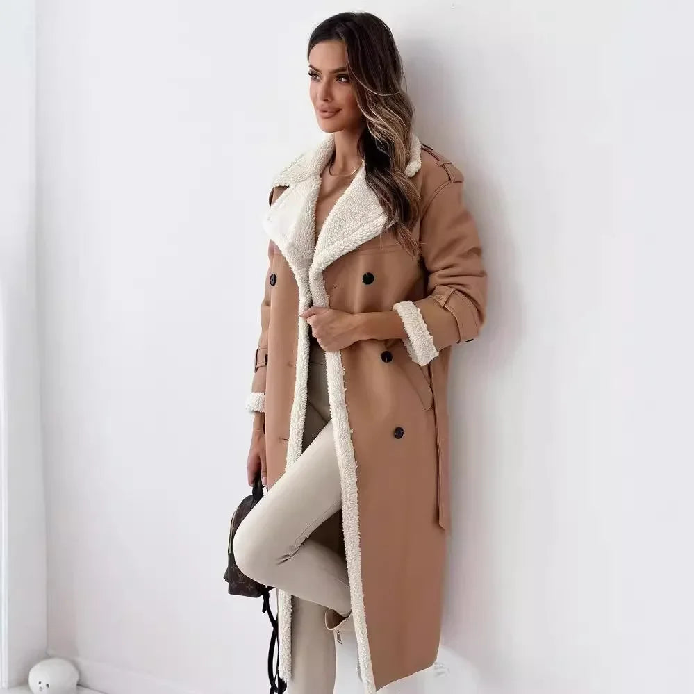 Woman wearing a tan coat with white fur lining against a white wall