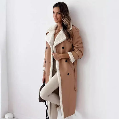 Woman wearing a tan coat with white fur lining against a white wall