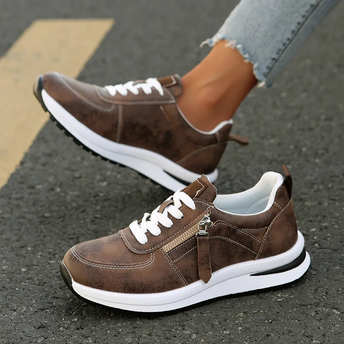 Brown sneakers with white soles on a pavement background