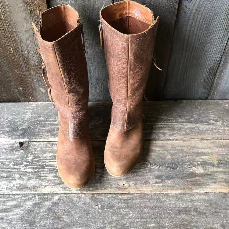 Pair of brown leather boots on a wooden surface