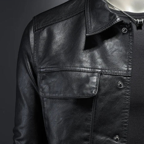 Close-up of a black leather jacket with a dark background