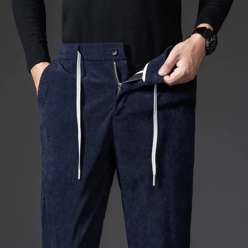 Navy blue corduroy pants with white drawstrings on a dark background