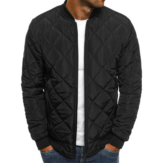 Black quilted jacket worn by a person on a white background
