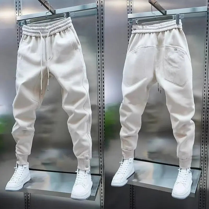 Beige jogger pants with white sneakers on a metallic surface