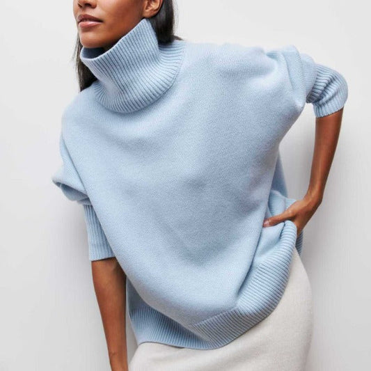 Light blue poncho worn by a person on a plain background