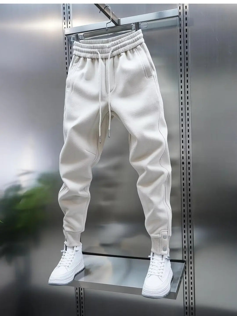 White jogger pants with a drawstring on a metallic surface