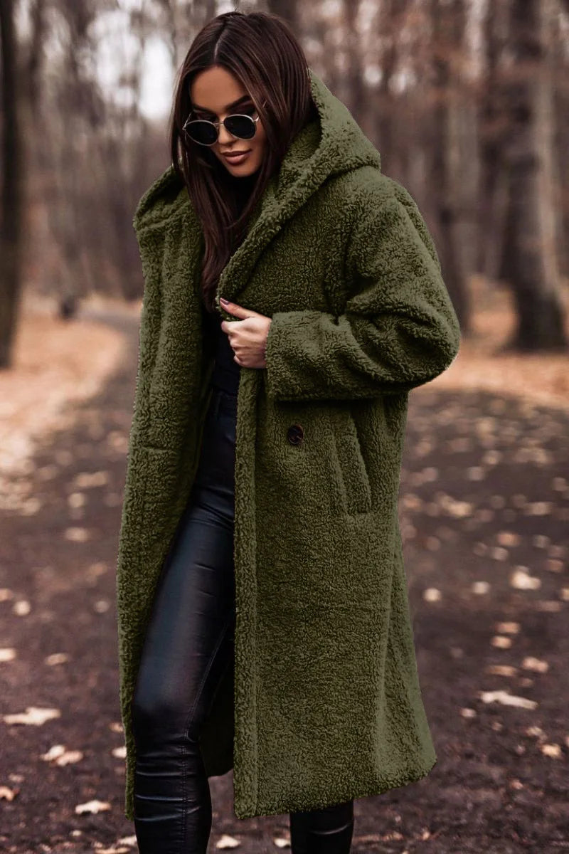 Woman wearing a green coat in a forest setting