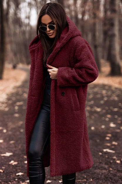 Woman wearing a burgundy coat in a forest setting