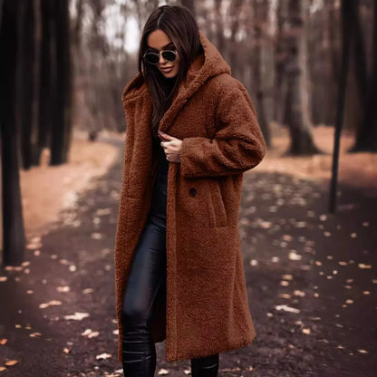 Woman wearing a brown coat in a forest setting