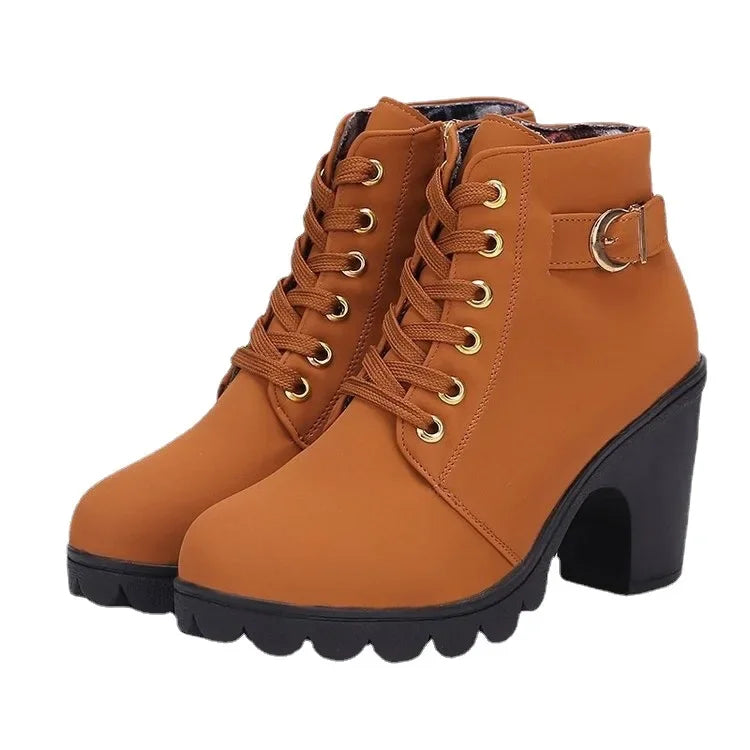 Brown ankle boots with gold laces on a white background
