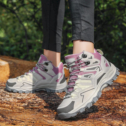 Hiking boots with purple accents worn by a person on a forest path