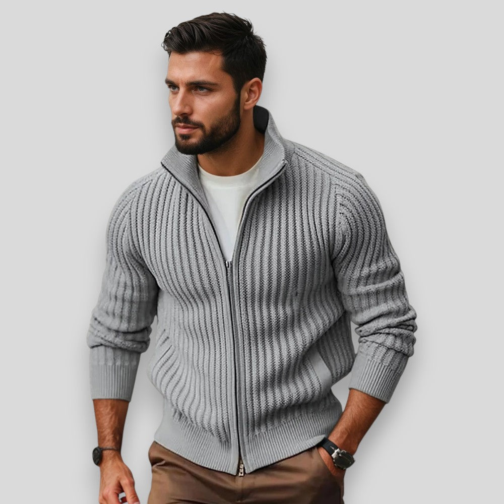 Man wearing a gray zip-up sweater against a light background