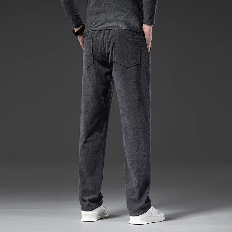 Person wearing dark gray jogger pants on a plain background