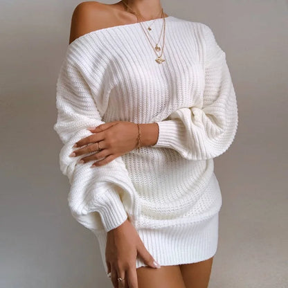 White knitted off-shoulder sweater worn by a person on a plain background