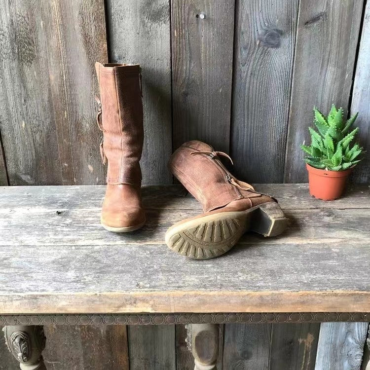 Pair of brown boots on a wooden surface with a rustic background