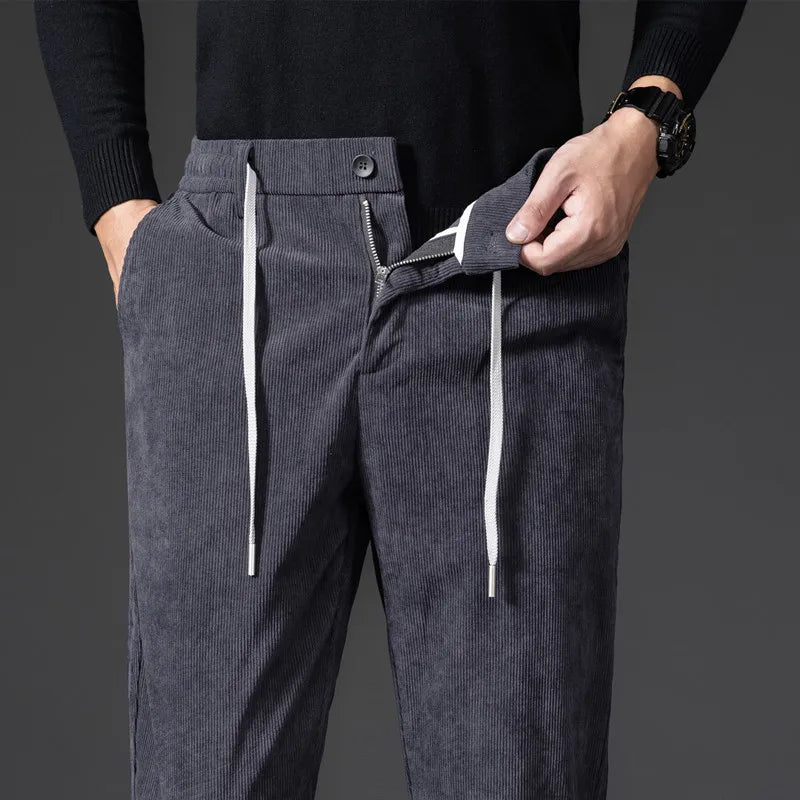 Dark gray corduroy pants with drawstrings on a dark background