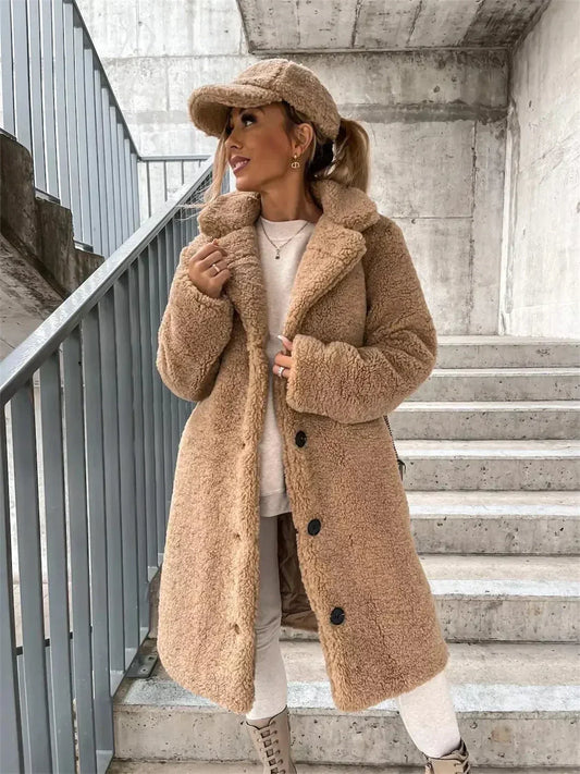 Woman wearing a beige coat and cap on a staircase