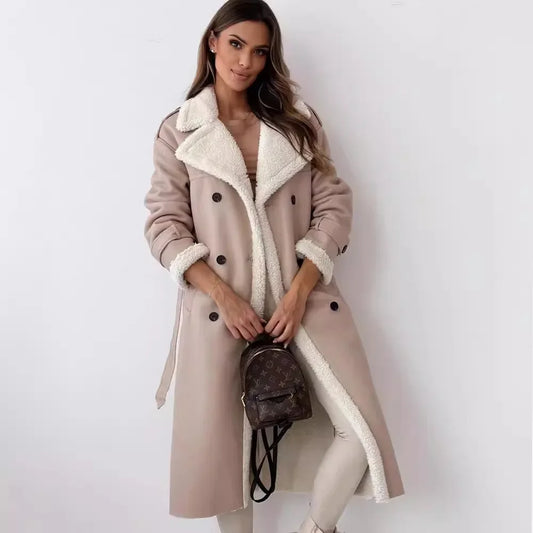Woman wearing a long beige coat with white fur lining, holding a brown backpack against a white background.