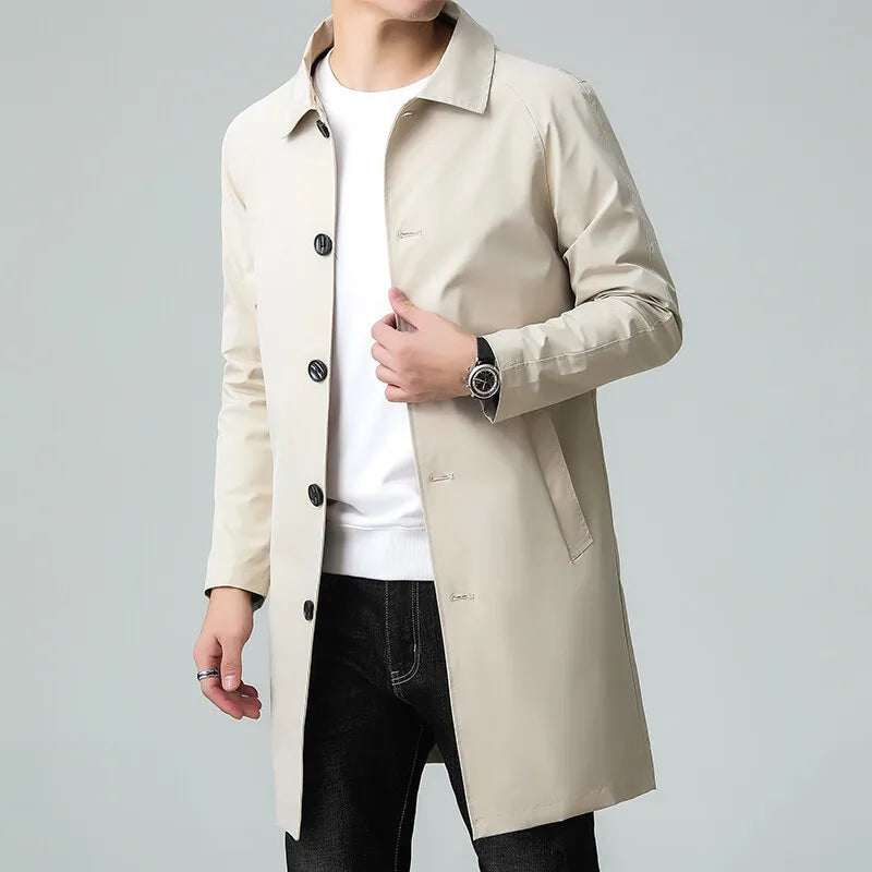 Beige trench coat worn by a person on a gray background