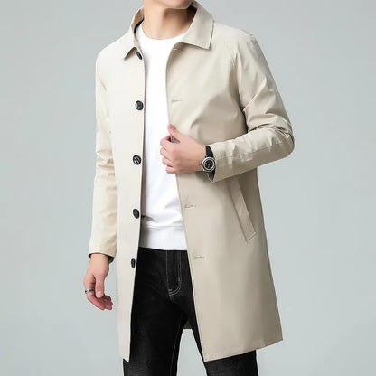 Beige trench coat worn by a person on a gray background