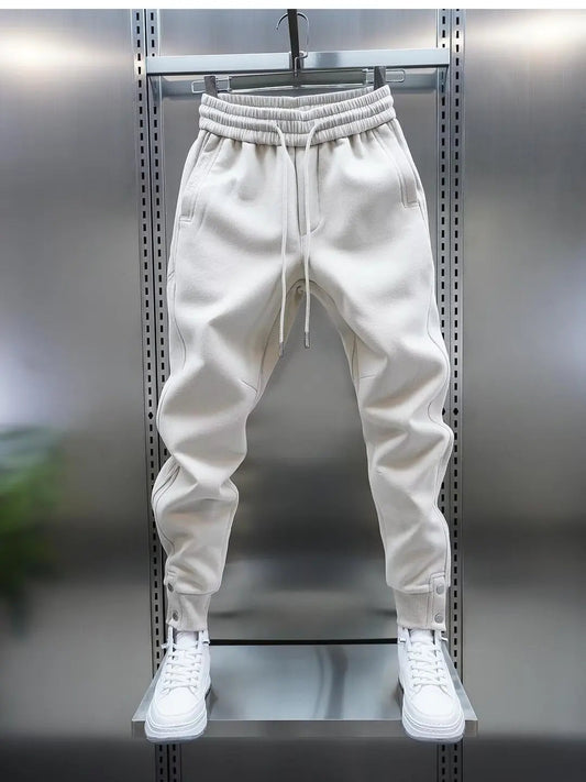 White jogger pants on a metal rack with white sneakers.