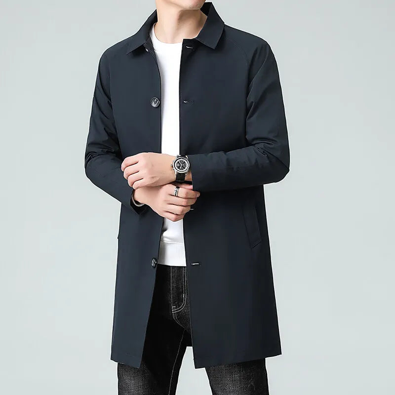 Person wearing a black coat over a white shirt on a gray background