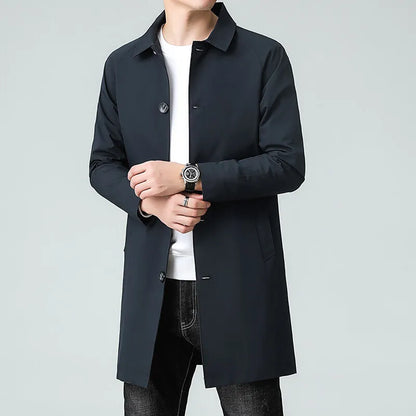 Person wearing a black coat over a white shirt on a gray background