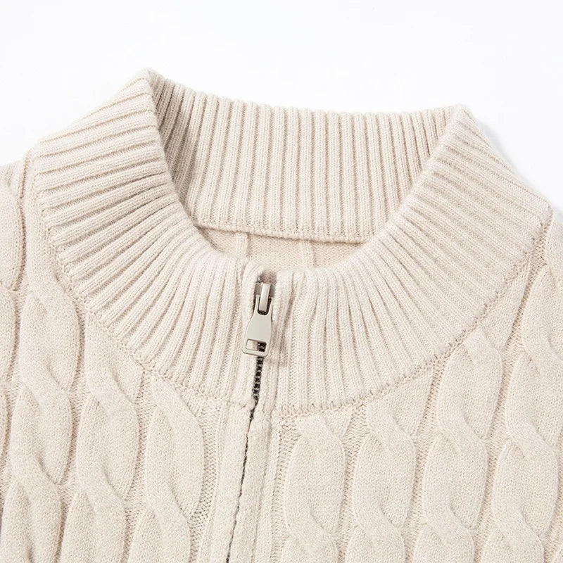 Close-up of a beige cable knit sweater with a zipper on a white background