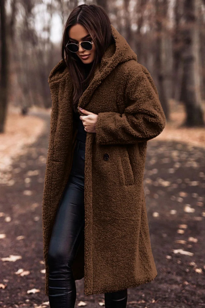 Woman wearing a brown coat in a forest setting
