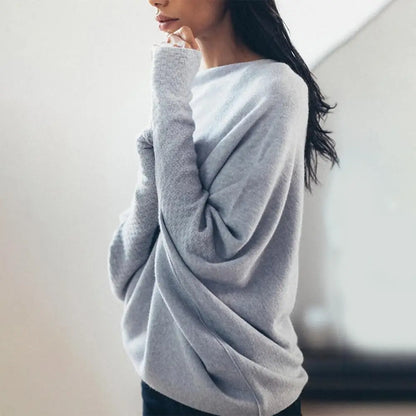 Woman wearing a light gray sweater against a neutral background