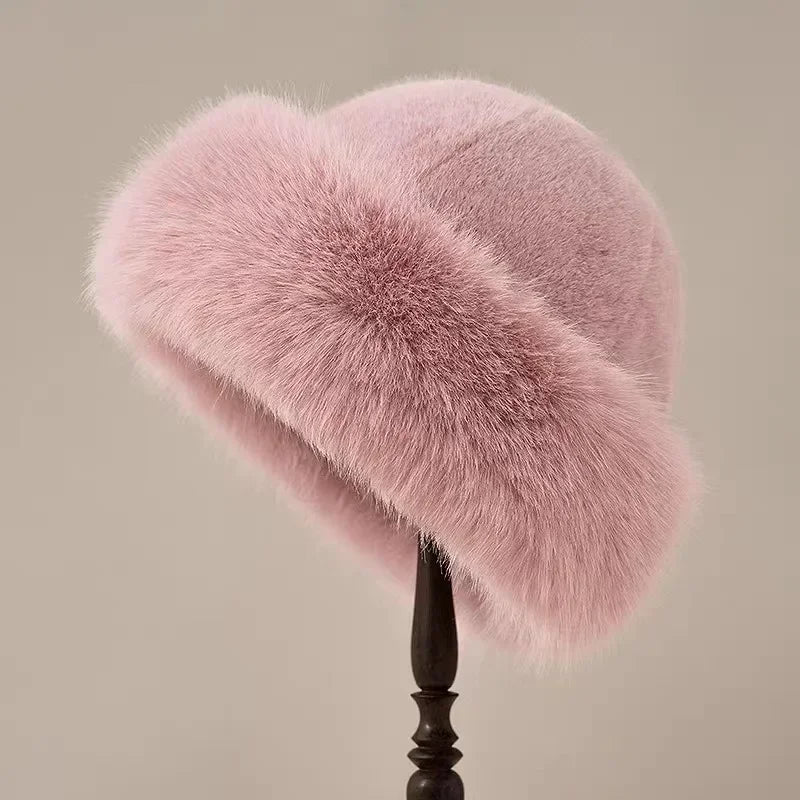 Pink fur hat on a stand against a neutral background