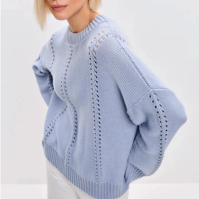 Light blue sweater with intricate patterns on a plain background