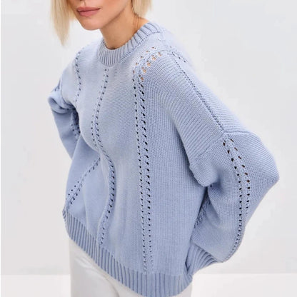 Light blue sweater with intricate patterns on a plain background