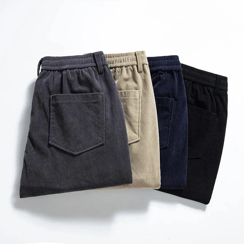 Four pairs of pants in different colors arranged on a light background
