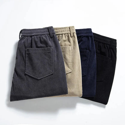 Four pairs of pants in different colors arranged on a light background
