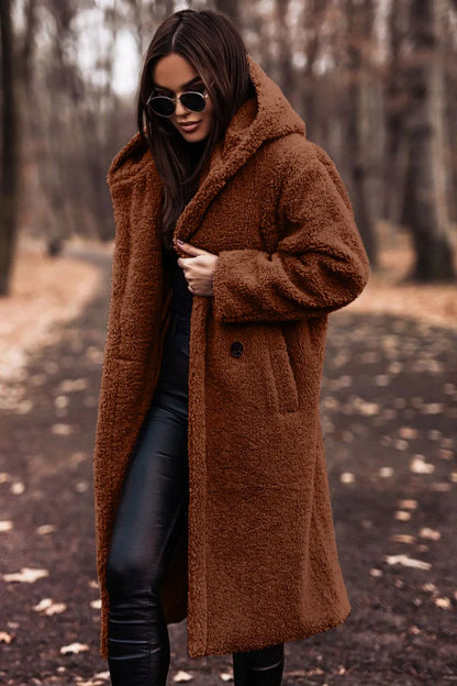 Woman wearing a brown coat in a forest setting