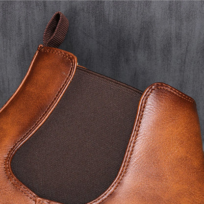 Brown leather boot with a black patch on a gray background