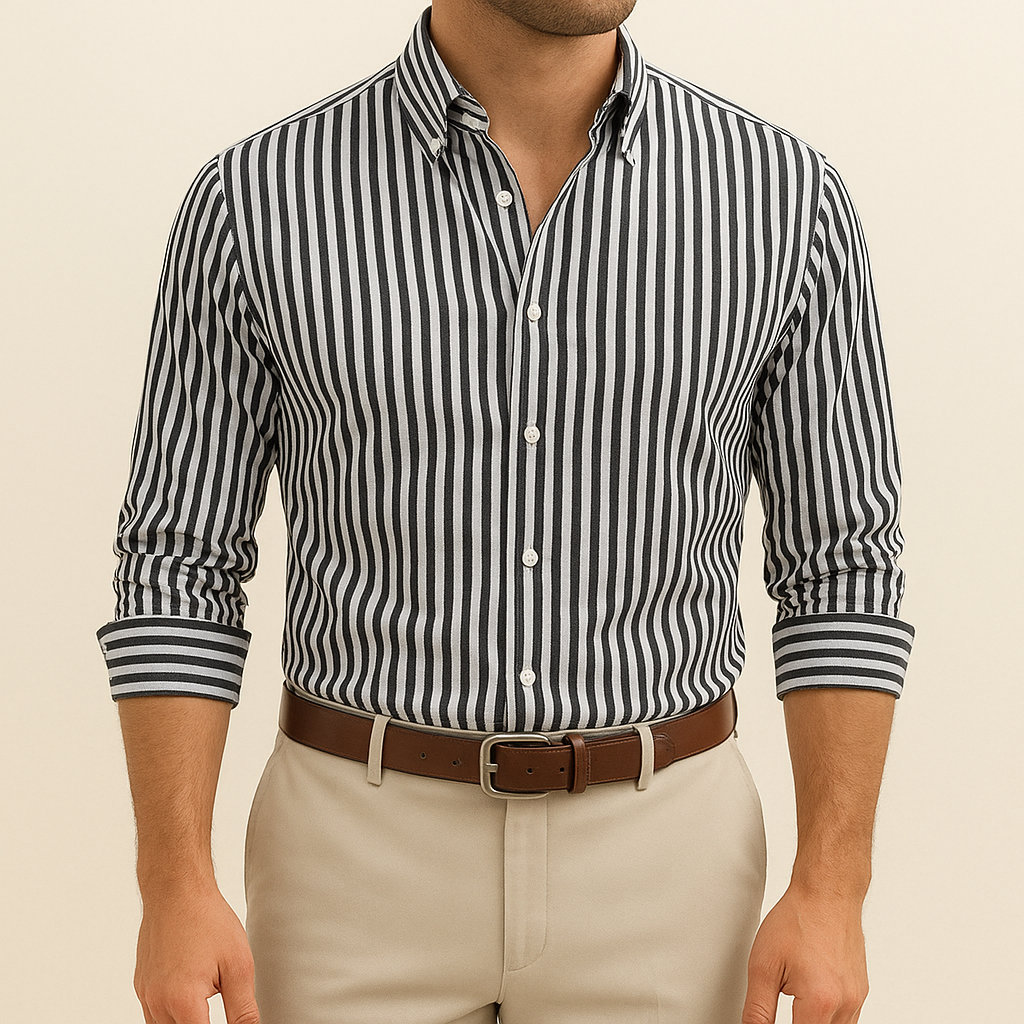 Man wearing a black and white striped shirt with beige pants on a beige background