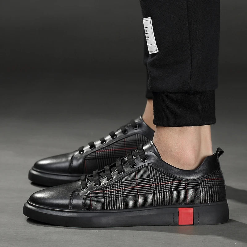 Black checkered sneakers with a red sole worn by a person on a gray background